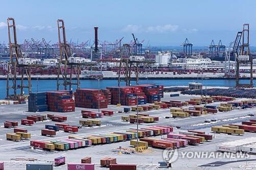 항구에 여러 개의 컨테이너와 대형 크레인들이 늘어서 있는 모습