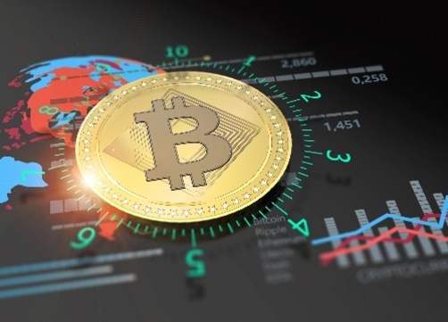비트코인 로고가 새겨진 금색 동전이 세계 지도와 그래프 위에 놓여 있는 이미지